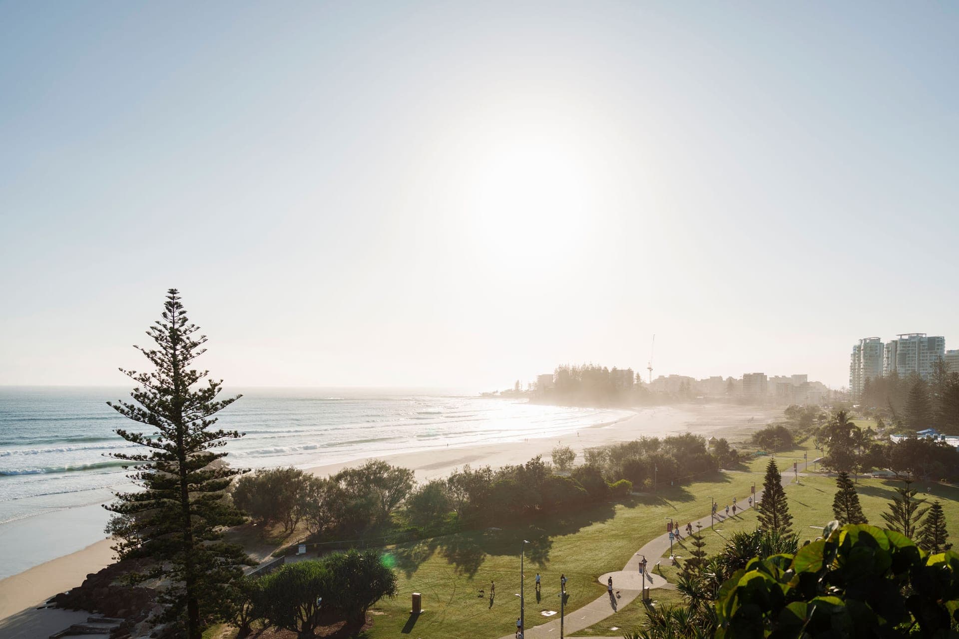 Surfers on the Oceanway path at Coolangatta in golden light
